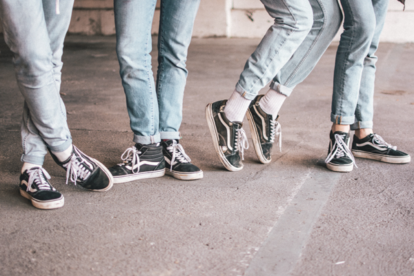 Beine von Menschen in Jeans uns Sneakers - Foto von Ben Weber